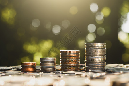 晨霭商业硬币堆叠在一起晨日照耀着市场成功设计图片