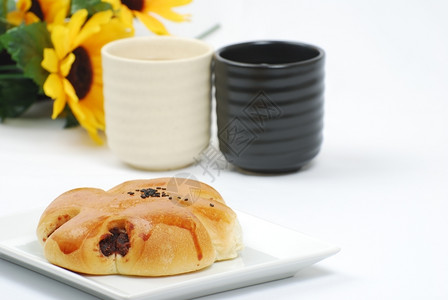 红豆面包有茶和鲜花背景果酱自然烘烤的图片