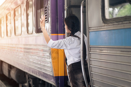 亚裔孕妇在火车上旅行站的路上手举打招呼亚洲人街道女士图片