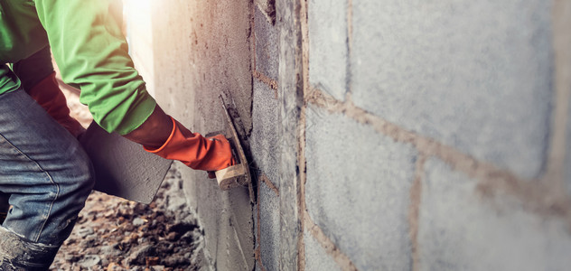 承包商建筑房屋墙上石膏水泥的工人劳动灰图片