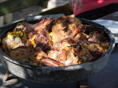 可口一顿饭烤猪肉加蔬菜和陶器煮熟的图片