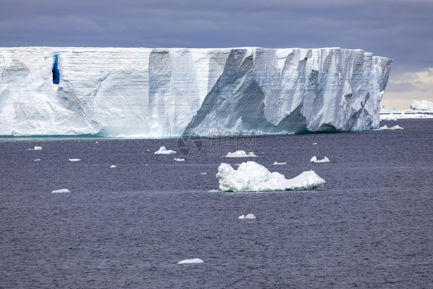 说谎无限的冷静巨冰山漂流穿过南极洲平静的海面图片