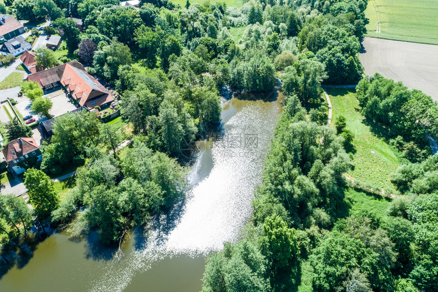 天线在Wolfsburg附近的村庄边缘有灌木丛和树从空气中抽取新豪斯城堡的池塘反射景观图片