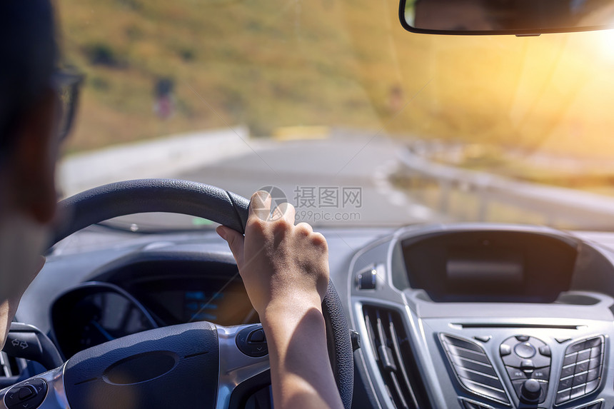 在背景挡风玻璃和道路的背景下女孩在开车时手握着汽的方向盘关注她手上的焦点技术控制人们图片