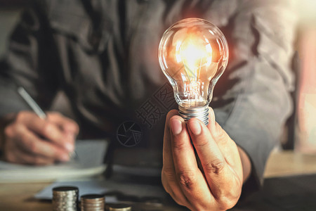 商人用手握着灯泡概念的并具有创新和启发精神力量金融的活图片