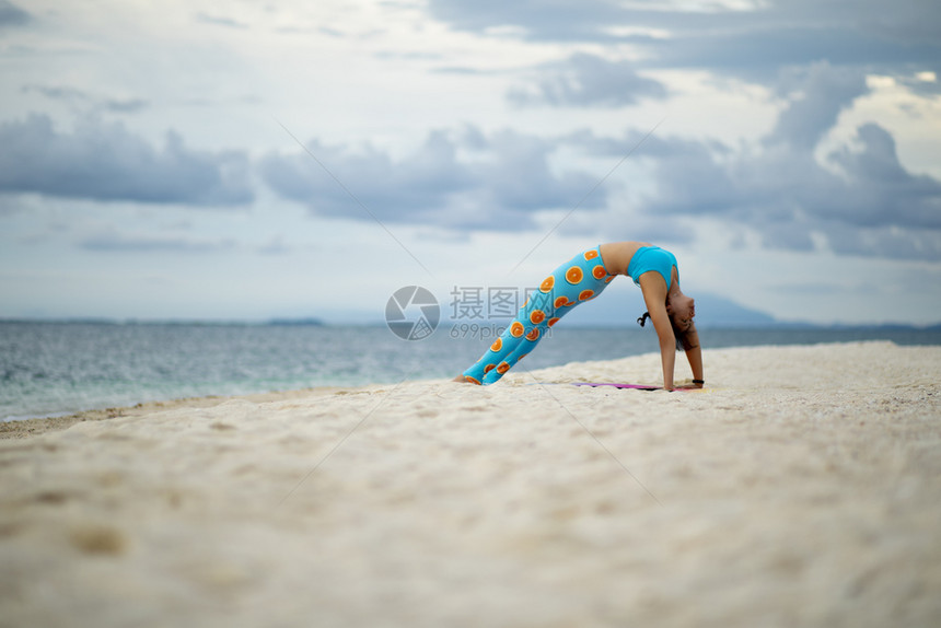 在沙滩上做瑜伽的女性图片