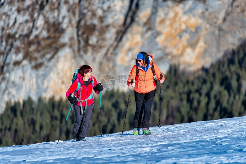 徒步旅行女幸福在雪中山上漫步的一对友好妇女图片