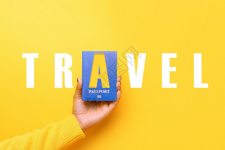 蓝色的国民籍护照携带黄背景世界旅行概念和图片