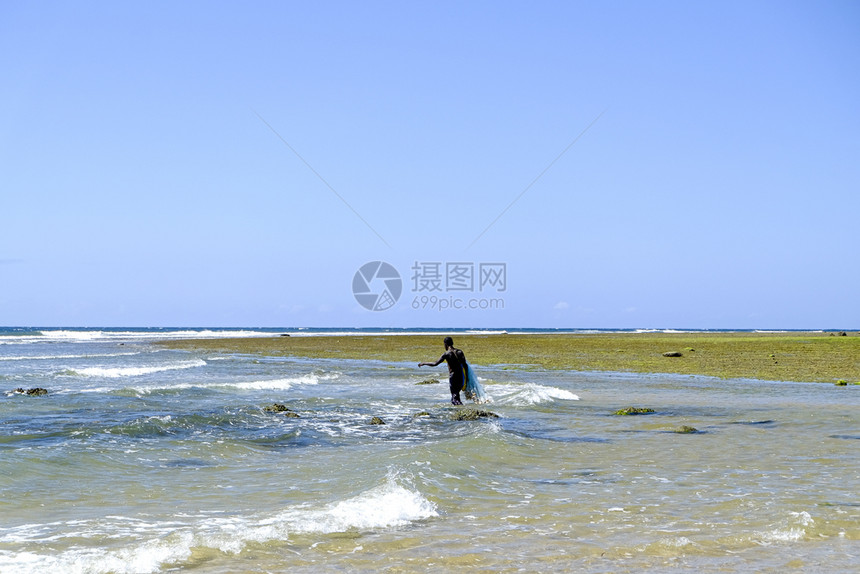 浅水中的非洲渔民和他网在浅水中捕鱼户外手动的费舍尔图片