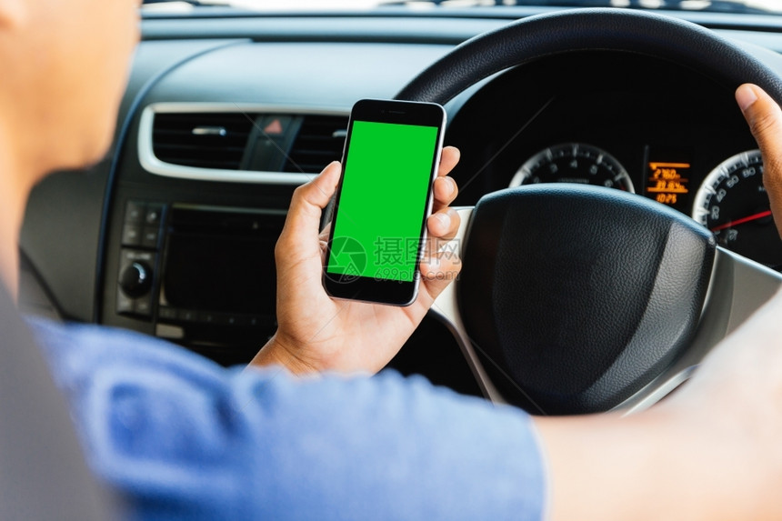 商业导航白色的使用应程序的男子在汽车里用手机方便调整的电话绿屏图片