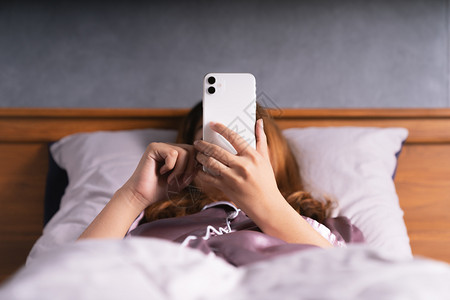 手松弛女妇醒来后在床上使用电话图片
