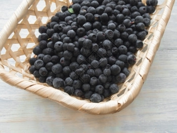 小篮子有新鲜的野生蓝莓几小块新鲜的野生蓝莓躺在鸡篮里小吃蓝色的水果图片