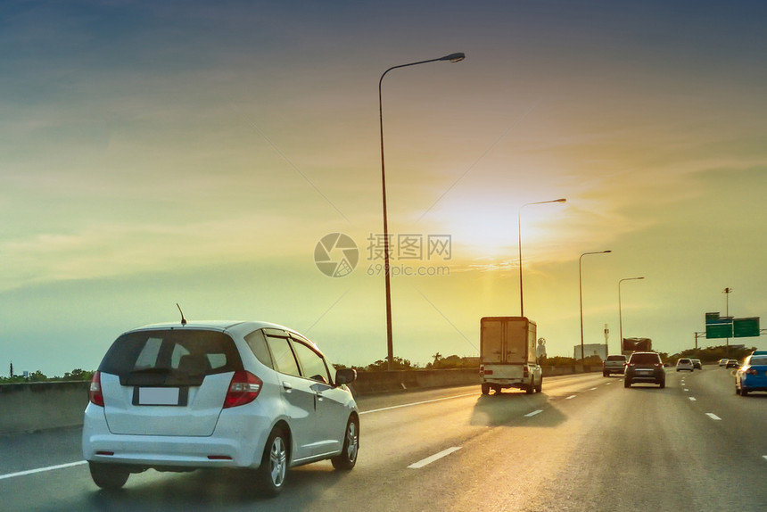公路上的汽车驾驶公路上的汽和日落背景运输正面银城市图片