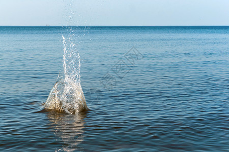 石头扔进水中泼从扔进中的石头上喷落蓝色的运动降低图片
