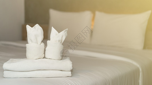在旅馆内装饰室铺在床上的白浴巾松弛洗卫生图片