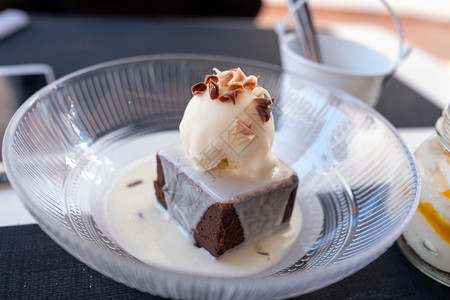 白色的蛋糕巧克力背景的香草冰淇淋一勺香草冰淇淋在白巧克力背景盘子图片