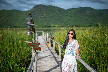 旅行年轻女站在木桥上以自然背景为本美丽的女孩图片