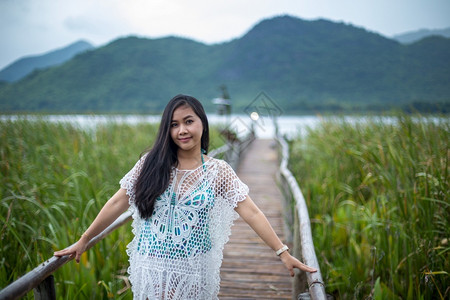 放松码头夏天年轻女站在木桥上以自然背景为本图片
