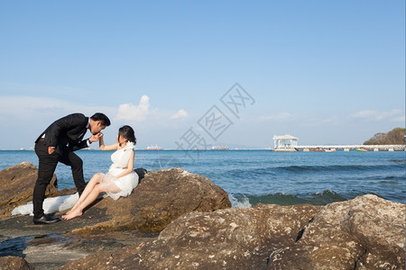纱海边岩石上的新娘和郎婚图片