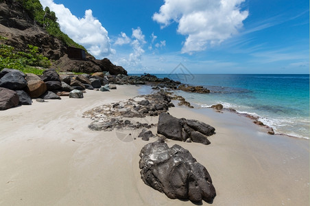 绿松石身体沙地上和山边有海的坡旁大块岩石西方图片