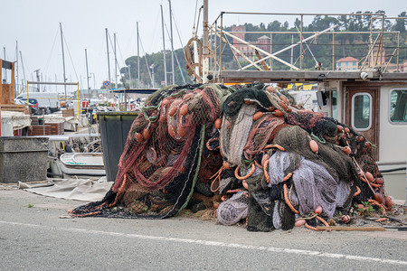 细节在意大利古里亚瓦拉泽港码头捕鱼日后堆积在水边的渔网上职业码头区背景图片