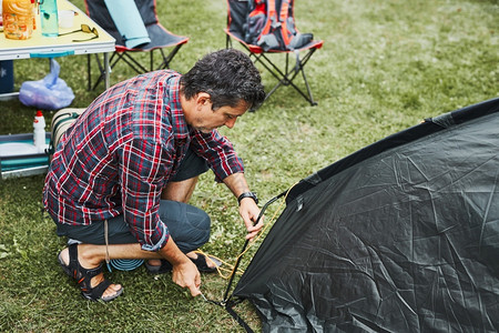 户外野餐搭帐篷的男人图片