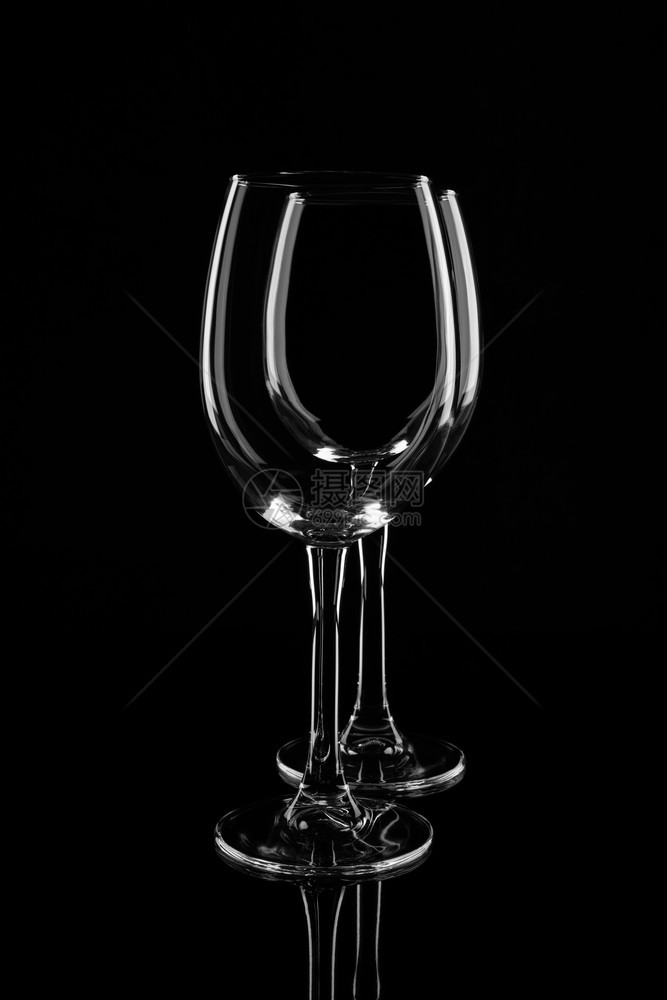 晚餐饮料瓶子两个空透明酒杯隔离在黑色背景上两个空透明酒杯隔离在黑色背景上图片