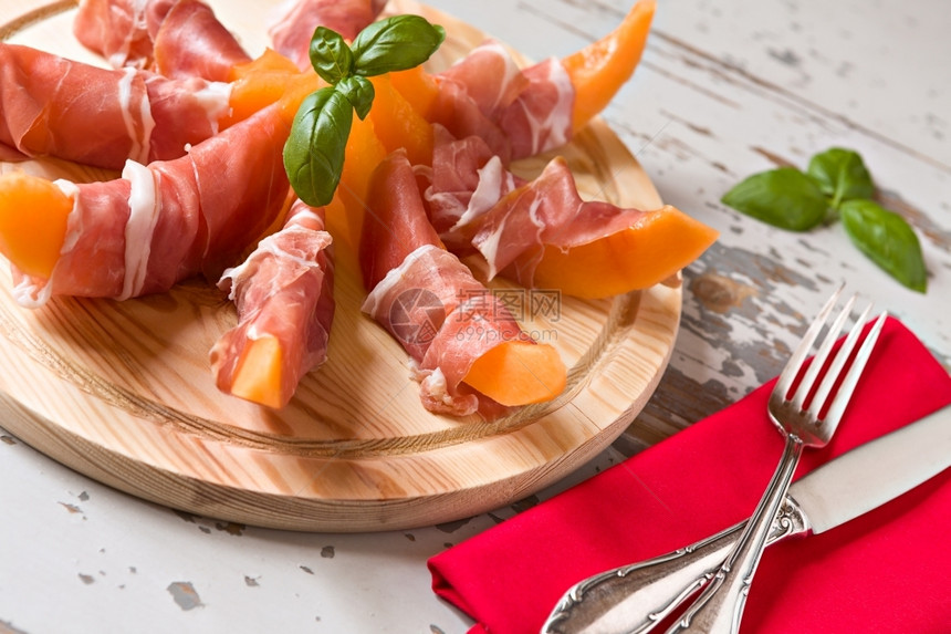 刀具意大利的切板配有正西乌托和甜瓜在木制背景上的意大利切板配有正西乌托和甜瓜的意大利切板水平的火腿图片