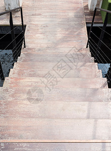 新的现代木制楼梯在小池塘上到城市公园的木制地板上白色的空图片