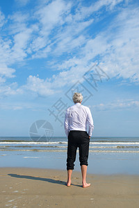 轻松身穿正式西装的生意人站在海上滩闲暇图片