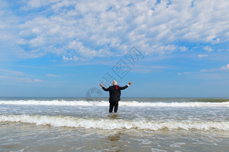 身穿正式西装的生意人站在海上某荷兰语景观图片