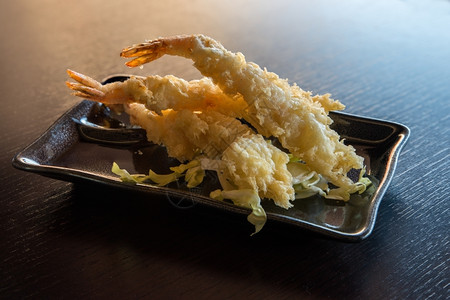 热的快速地金黑盘上配有酱汁和蔬菜的日本食深炸薯条图片