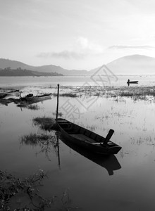 农村冷清早晨宁静的湖以黑黄白色音调渔民在那里生活船只在地表水上反射图片