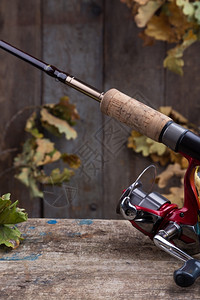 娱乐钓鱼铲球旧木板和叶子上挂有背景捕鱼钩图片