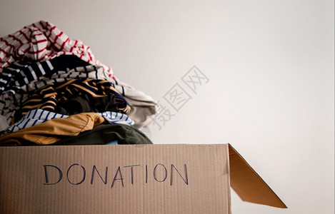 捐衣服准备捐赠概念将旧衣服制成一个捐赠箱着重文字培养随意的背景