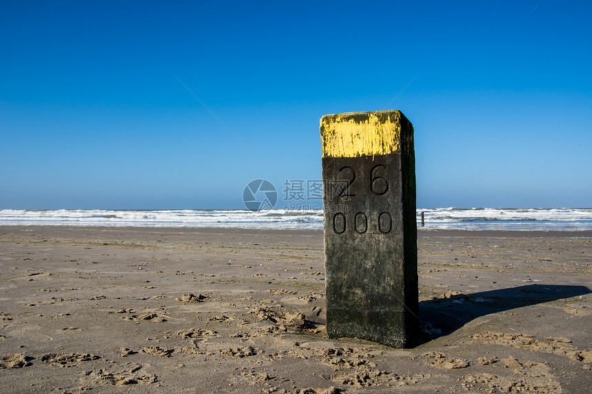 天空石头荷兰海滩上的木杆邮政图片