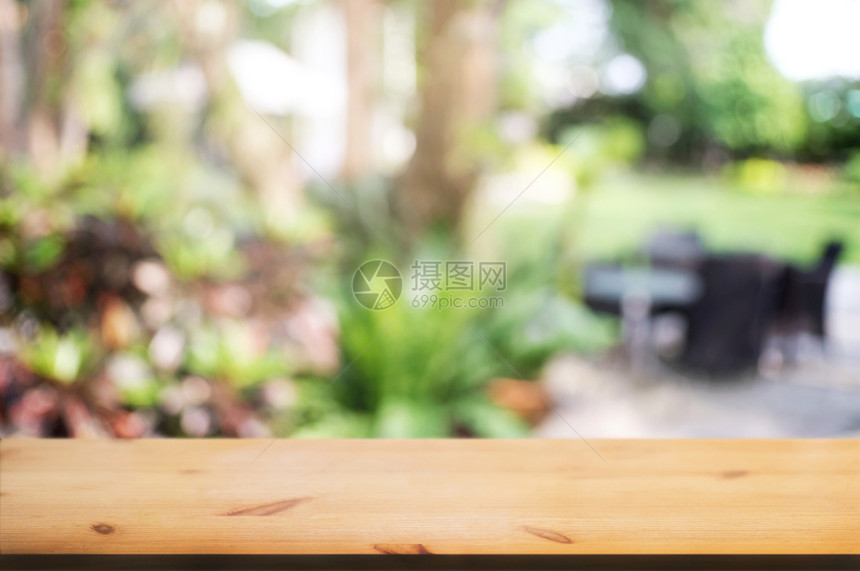 在花园背景的模糊家庭咖啡馆前面的木板桌内部空白色图片