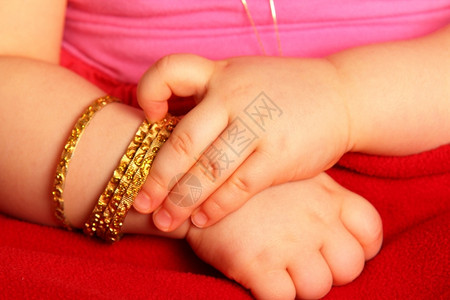 新生儿投标压痛带着金手镯的婴儿与黑暗红色隔绝图片