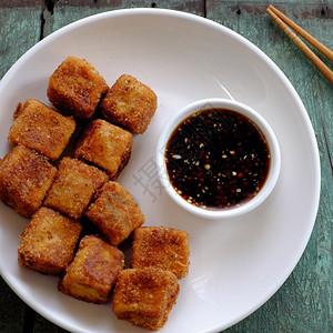 黄豆酱煎豆腐越南烹饪的节食素品有香料力的油豆腐面粉薄煎绿叶背景的自制食物素大豆酱和吃美味的木制背景