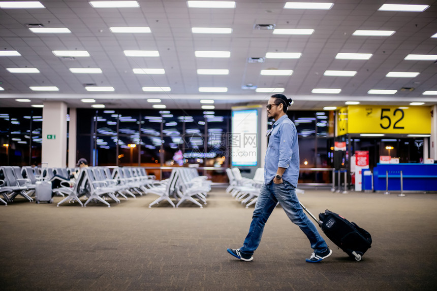 亚洲人旅行者在机场步和运输李箱的亚洲人旅行航空公司成人家庭图片
