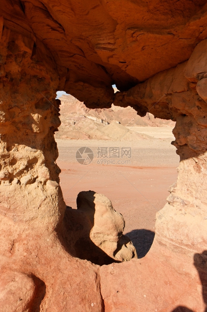 裂缝中间干燥沙漠橙色石岩的窗口图片