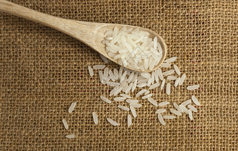 食物粮以粗布为背景的木勺子中亚洲未煮白米传统的图片