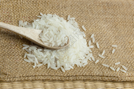 谷物以粗布为背景的木勺子中亚洲未煮白米健康棕色的图片