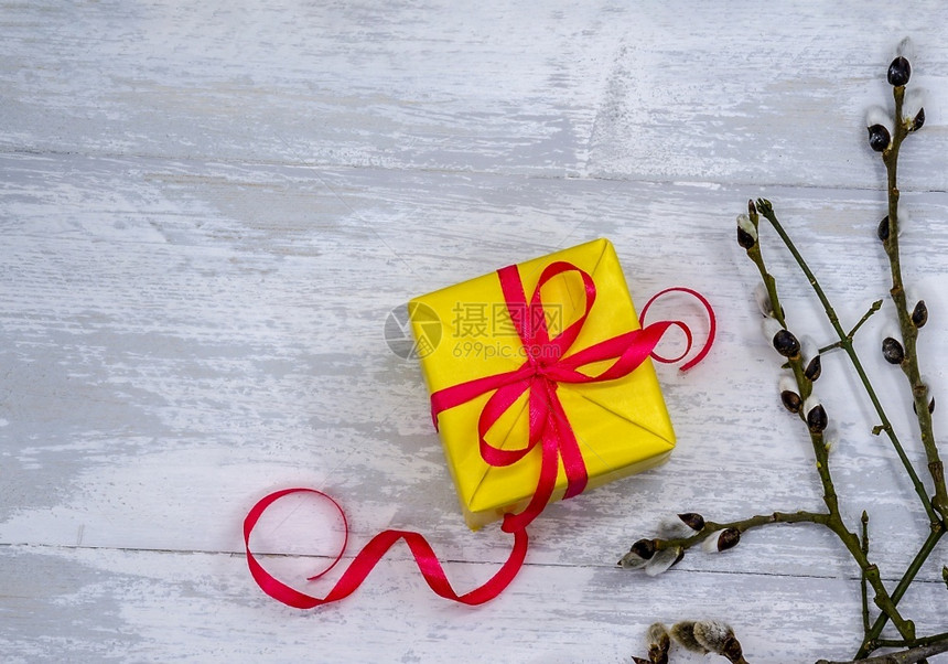 柳枝和礼物灰色背景上有黄礼物带红丝的礼盒柳枝和带红丝的礼盒灰色背景上有黄礼物盒子那里红色的图片