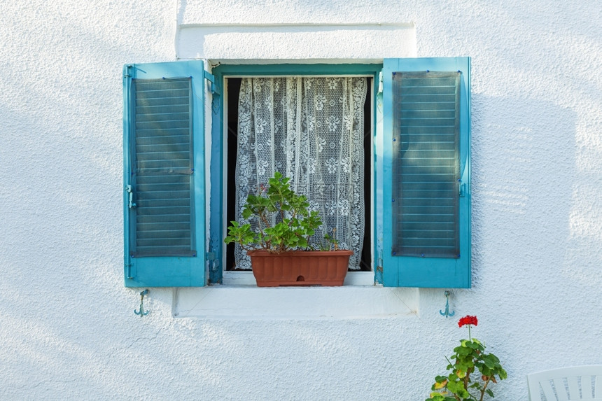 正面颜色花园希腊科孚白墙和鲜花上有蓝色百叶窗的开放口图片