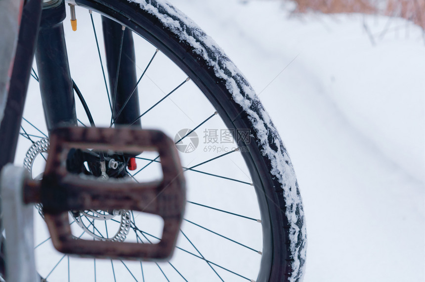 压力自行车在冬天积雪的路背景自行车轮子在积雪的路背景自行车轮子户外场景图片