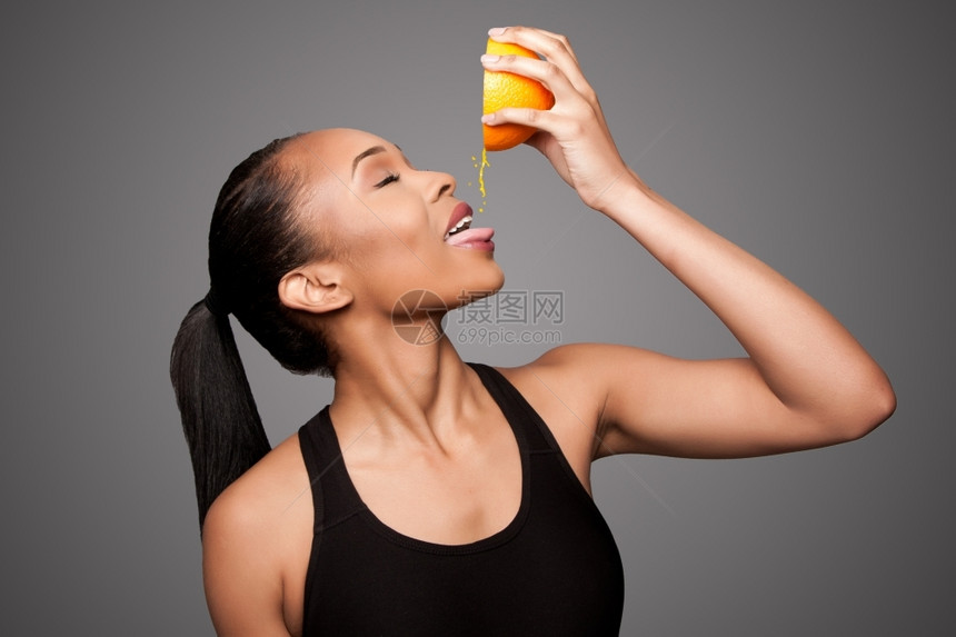 美丽的健康快乐黑人亚洲女挤压着美味的橙子果汁红番茄水亚洲人普通话舔图片