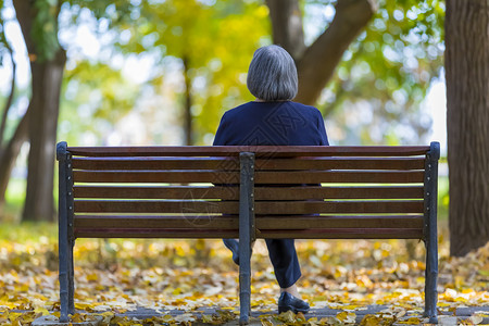 陈年秋天公园坐在长椅上的老年妇女放松微笑图片