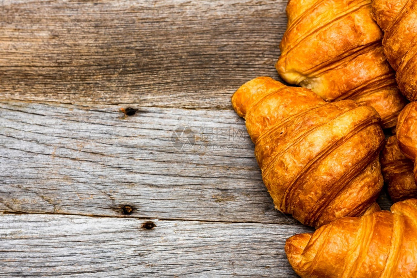 卷美味的传统新鲜羊角面包在木板上孤立法国早餐概念图片