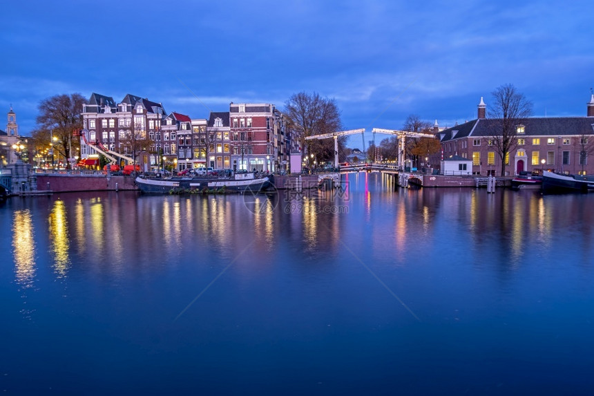 传统的首都发光日落时在荷兰阿姆斯特丹尔河市风景图片